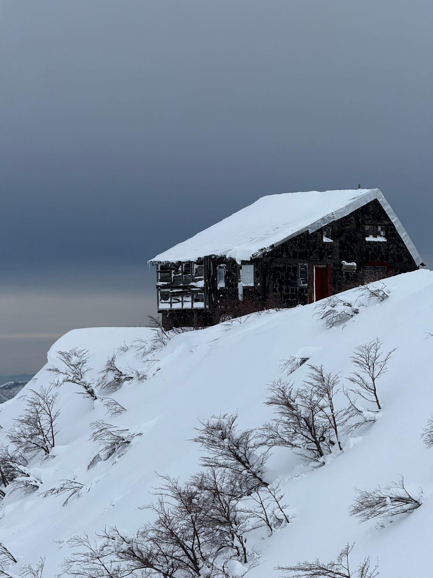 Refugio de piedra cubierto de nieve en la montaña
