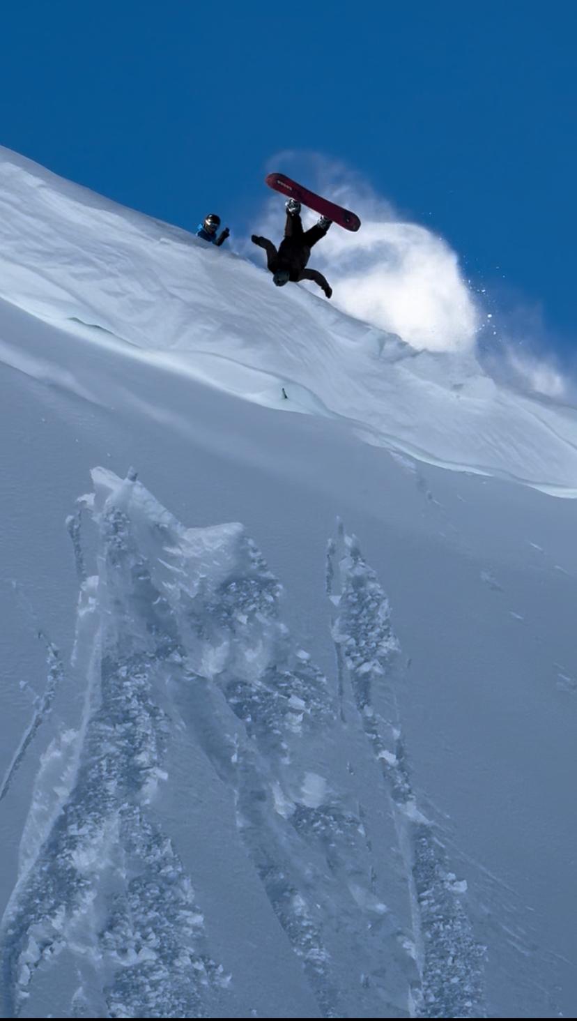 Snowboarder volando boca abajo en un salto épico