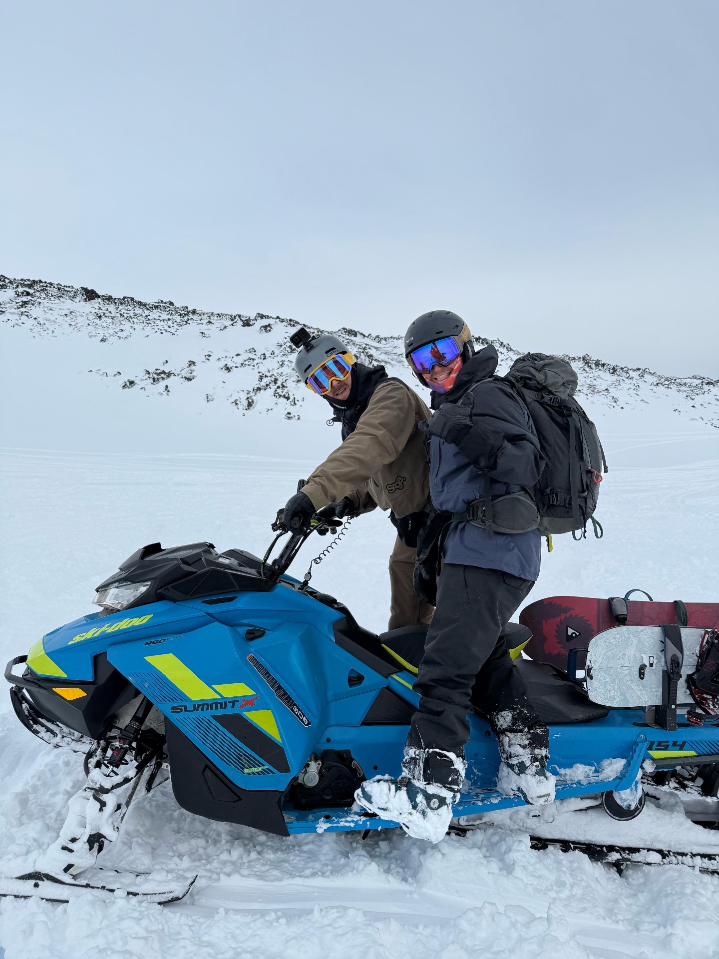 Piloto y snowboarder sobre Ski-Doo Summit en la cumbre nevada